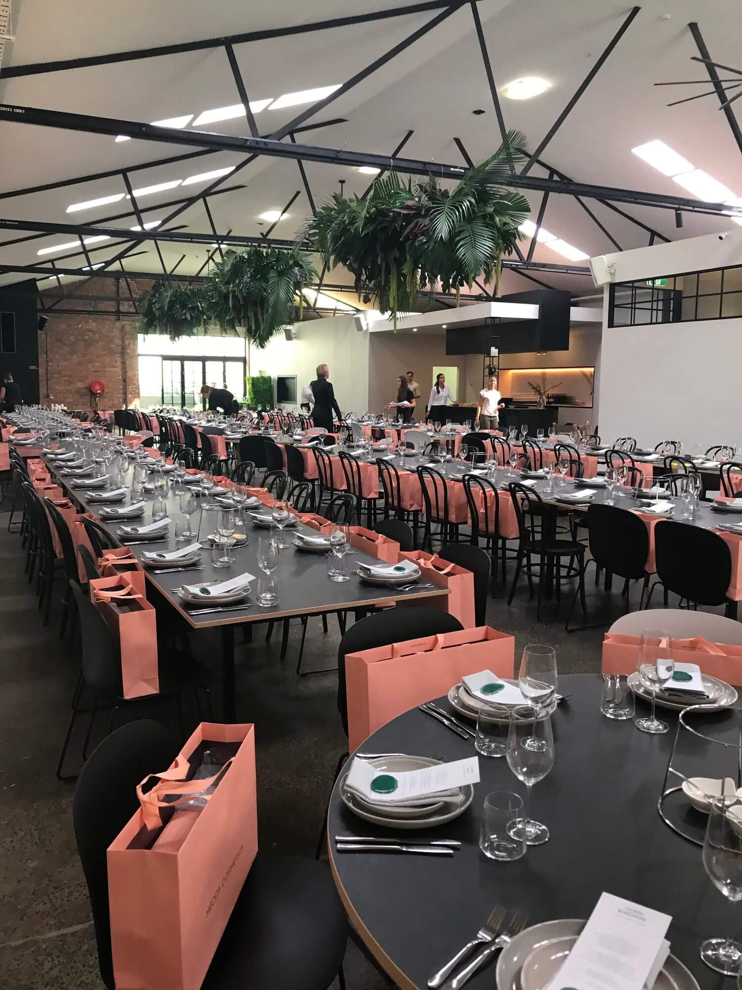 A spacious room in Melbourne's warehouse venue, all set for a dinner party with tables and chairs.