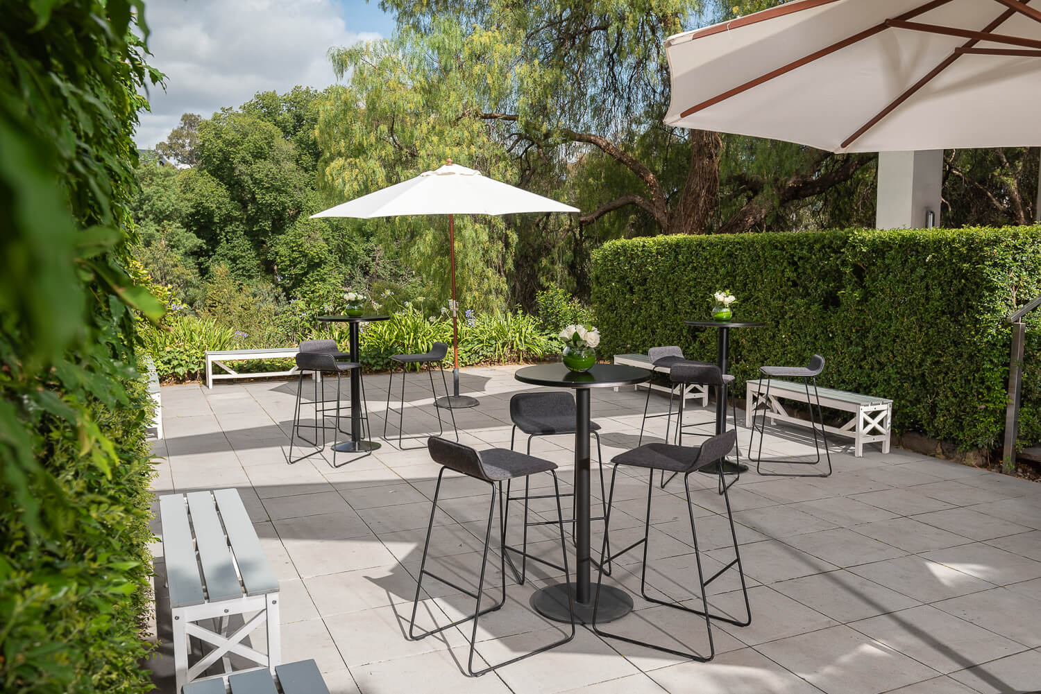 Outdoor seating area at Leonda by the Yarra, featuring tables and umbrellas for a delightful al fresco experience.