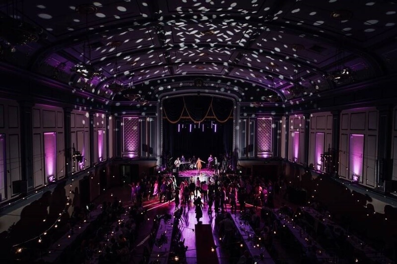 A wedding reception at Malvern Town Hall with beautiful purple lights illuminating the large hall.