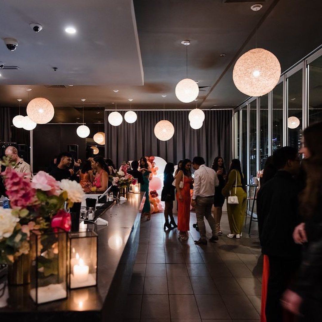 A vibrant bar scene with a crowd of people and stunning floral decorations. The ultimate choice for bar or bat mitzvah venues in Melbourne!