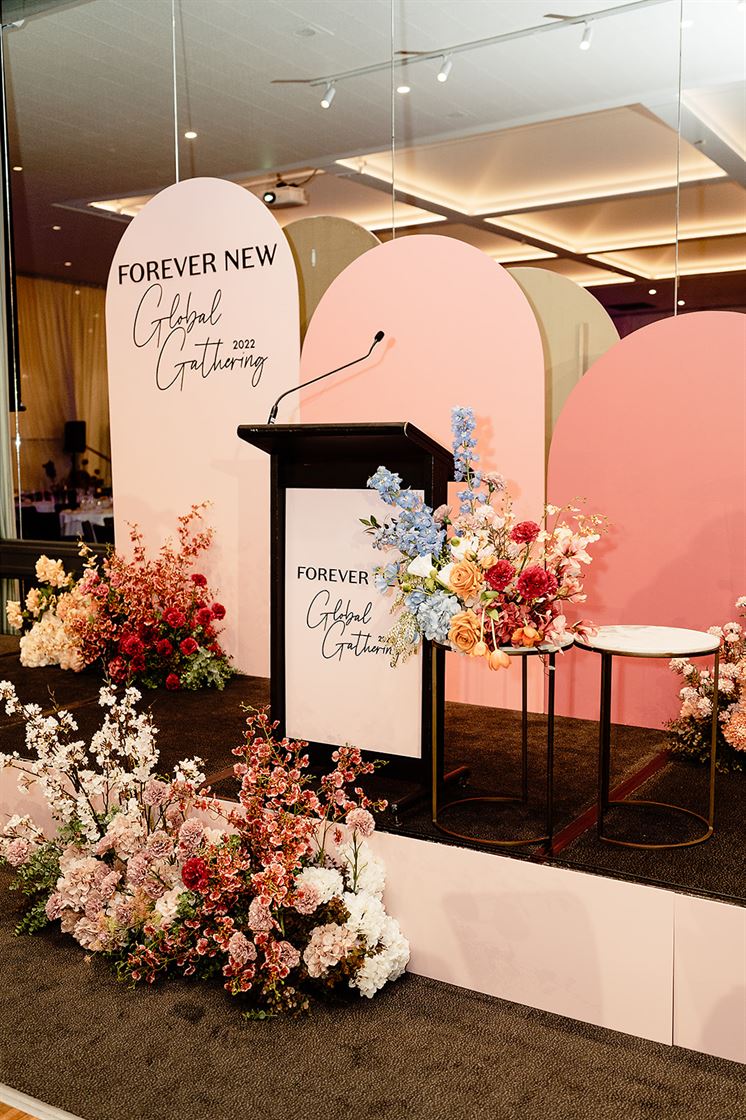 A stage with a podium and flowers, ready for a fashion show at a trendy runway venue.