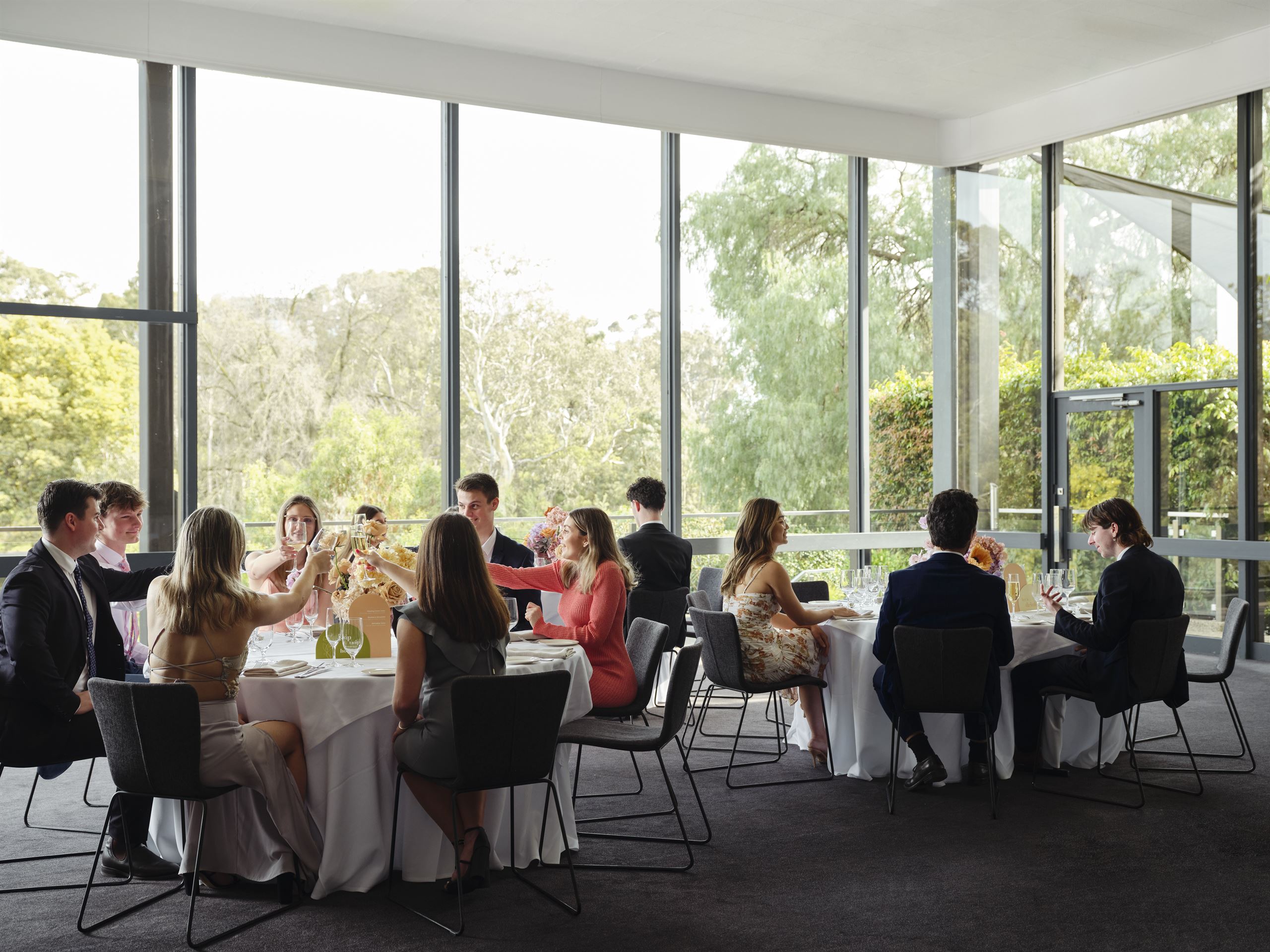 A bustling room filled with people sitting at tables, enjoying an event at one of the School Formal Venues in Melbourne.