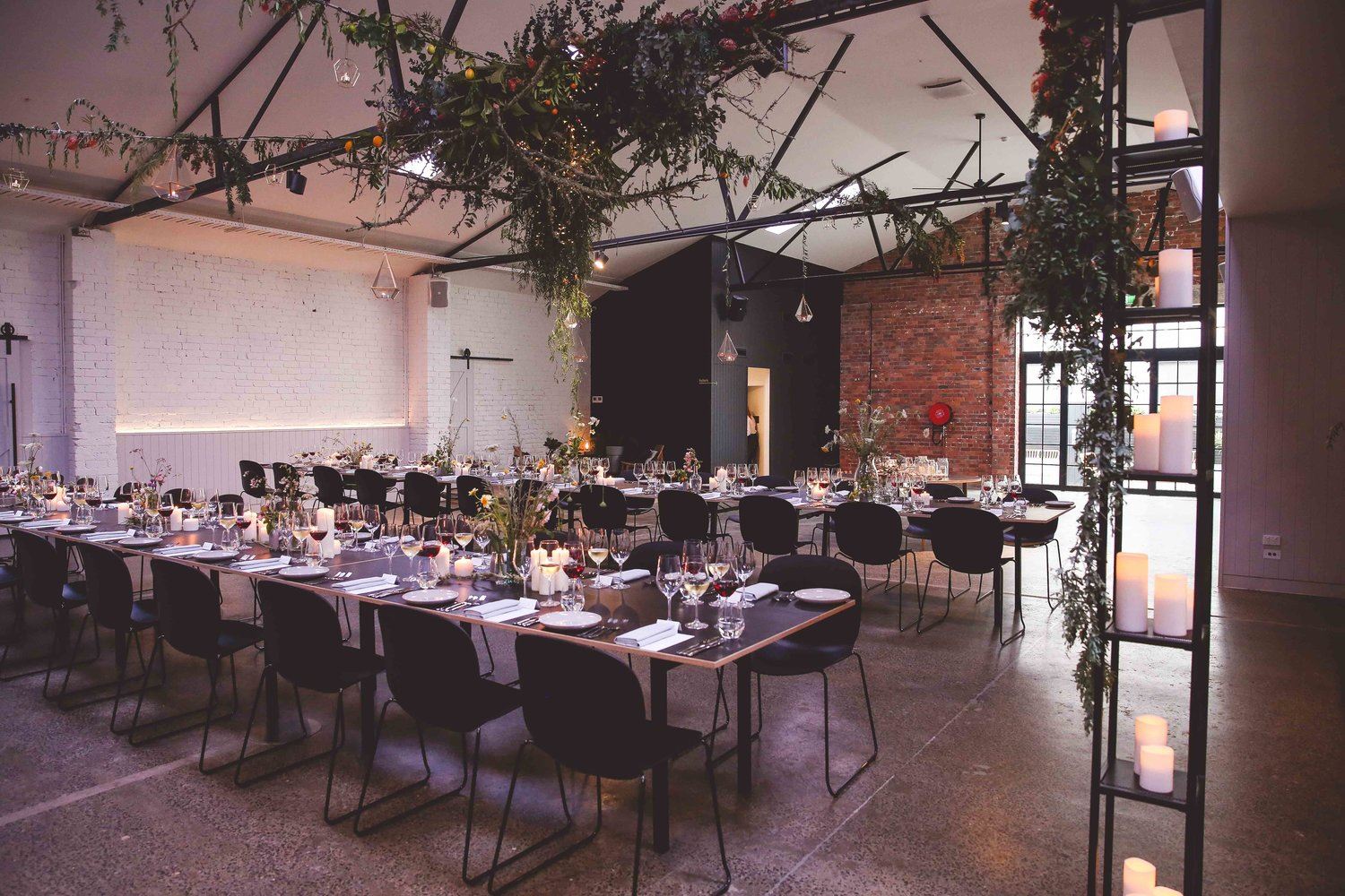 Rows of tables in a warehouse space, perfect for Christmas parties in Melbourne.