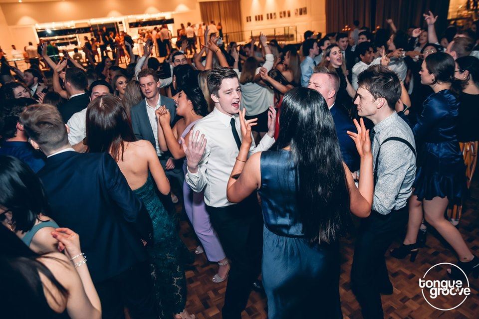A lively crowd of friends dancing at a school event, enjoying the party vibes and creating unforgettable memories together.