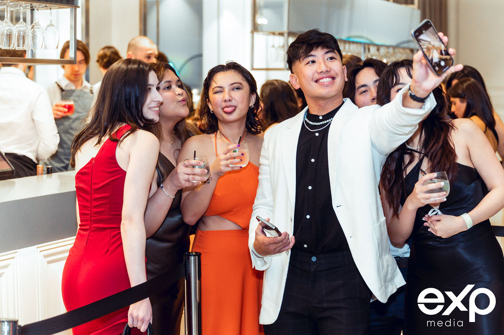 A lively group of people taking a selfie at a university ball venue in Melbourne.