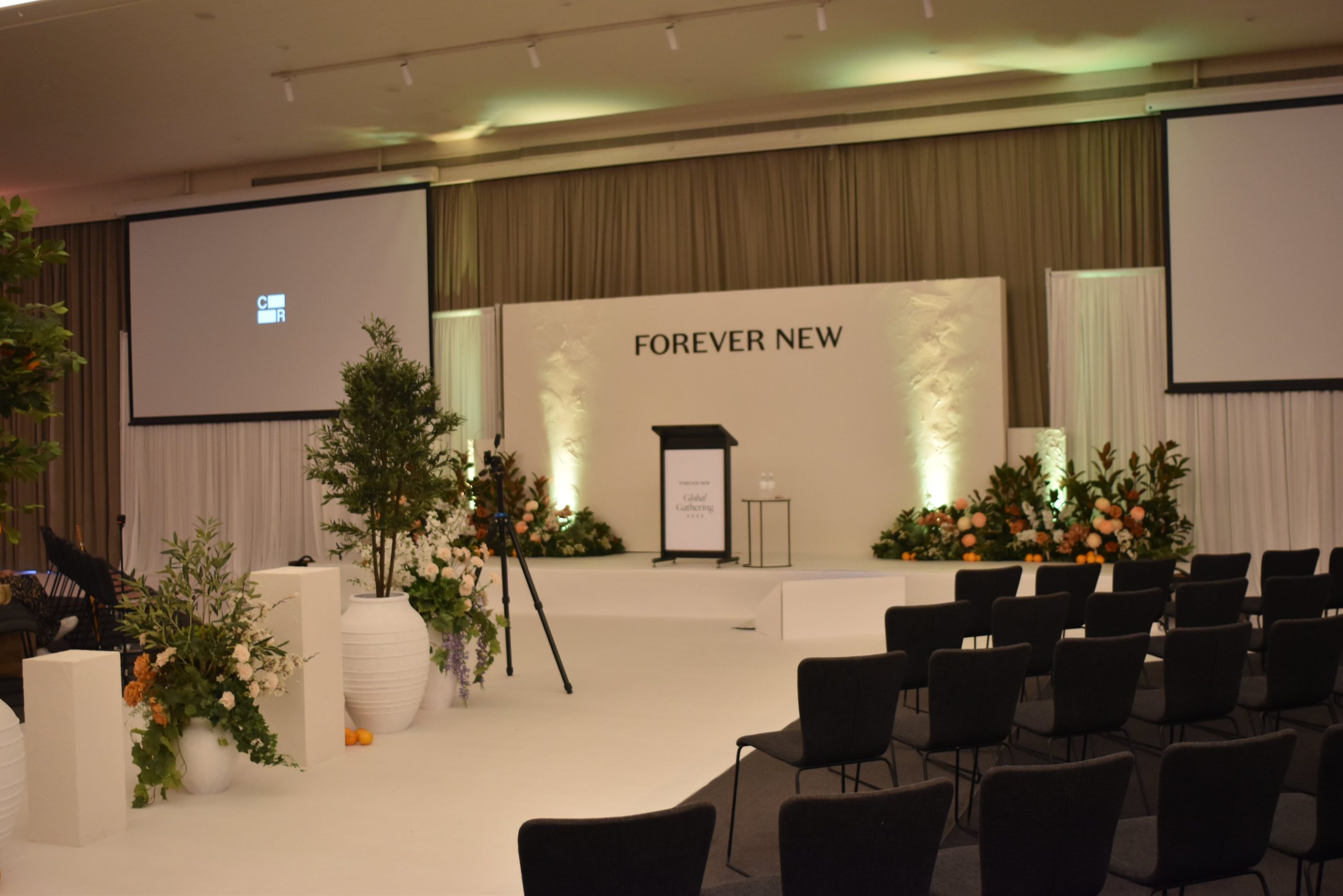 A fashion runway stage adorned with a podium and beautiful flowers, set for a stylish event.