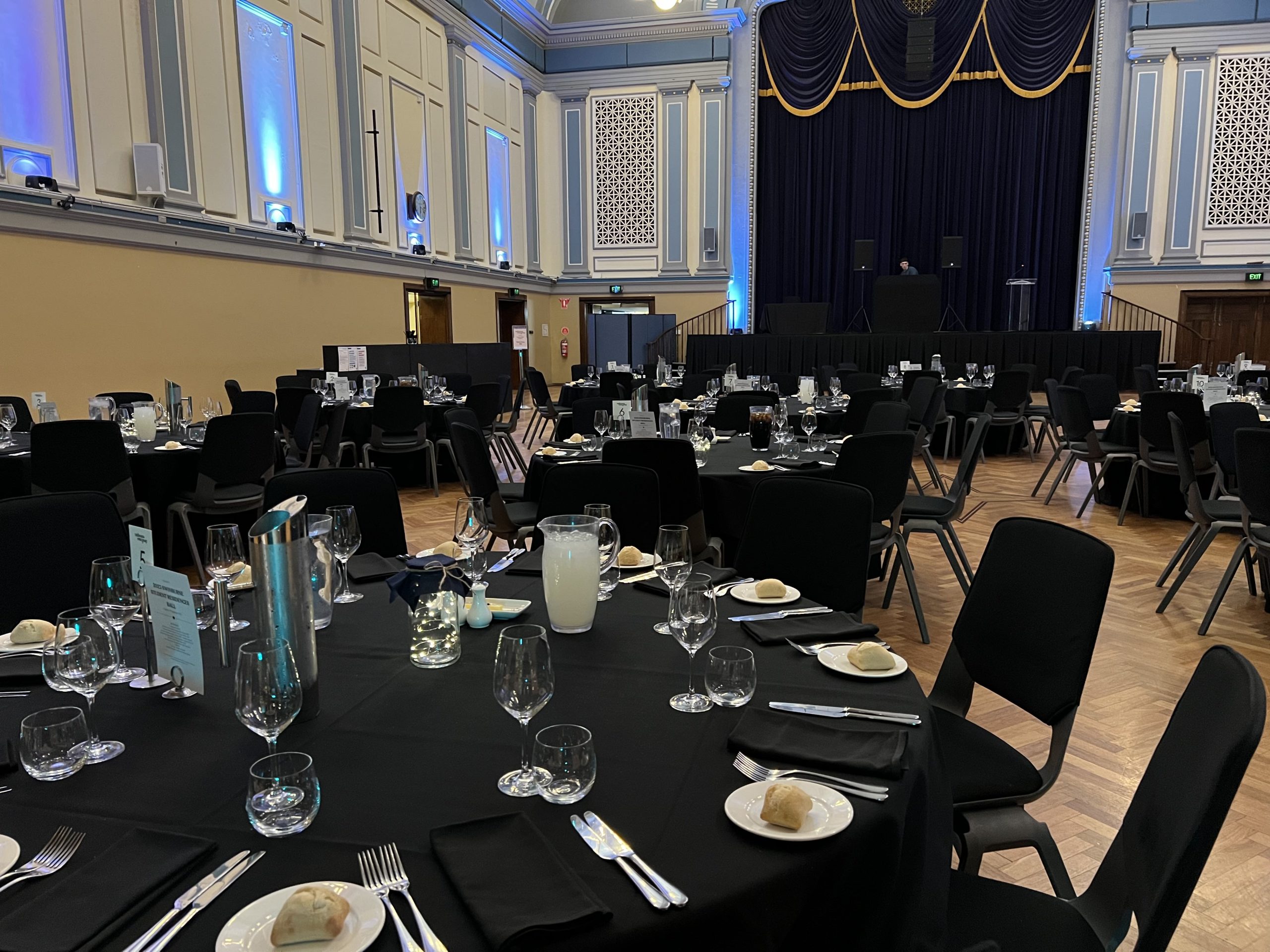 A spacious room at Malvern Town Hall events, filled with tables and chairs for a grand banque